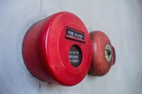 Retro fire alarm components attached to a white wall, such as a red break g.. Stock Photos