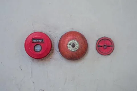 Retro fire alarm components attached to a white wall, such as a red break g.. Stock Photos