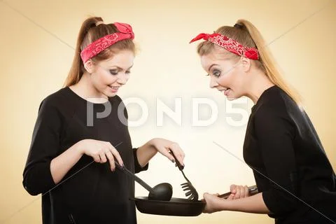 Retro girls cooking and frying on pan. Stock Photos