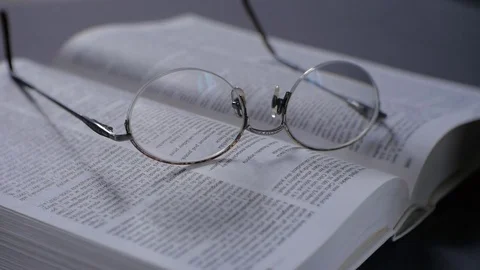 Retro glasses on the book. Camera closeup. Shallow depth of field - macro. 動画素材 73462078
