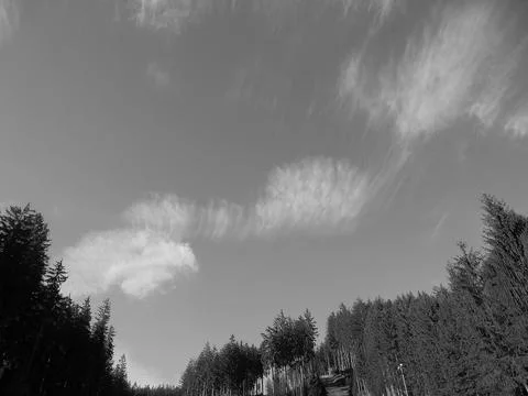 Retro image - Beautiful sparse clouds on a blue sky over mountain forests. Stock Photos