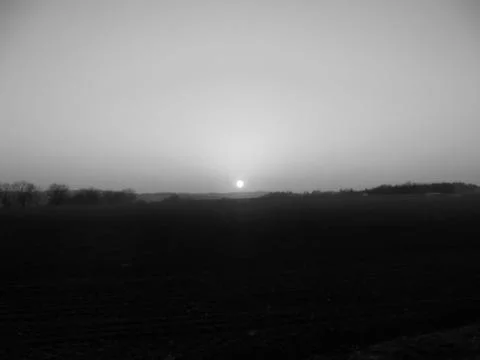 Retro image - Marvelous sunset over dark fields under bright sky. Stock Photos
