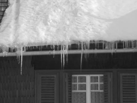 Retro image - Slightly blurred image of snow and icicles on a roof of village Stock Photos