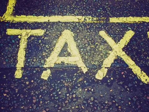 Retro look Tax picture Vintage looking Tax sign in yellow over gray asphal... Stock Photos