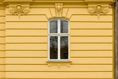 Retro looking window on a yellow facade Stock Photos