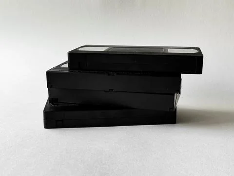 Retro nostalgia: stack of vintage vhs tapes against neutral background Stock Photos