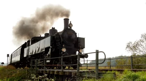 Retro nostalgic scenery of steam engine train locomotive crossing road. 库存影片 43558660
