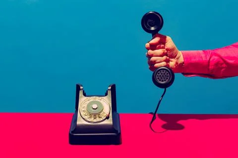 Retro objects, gadgets. Female hand holding handset of vintage phone isolated on Stock Photos