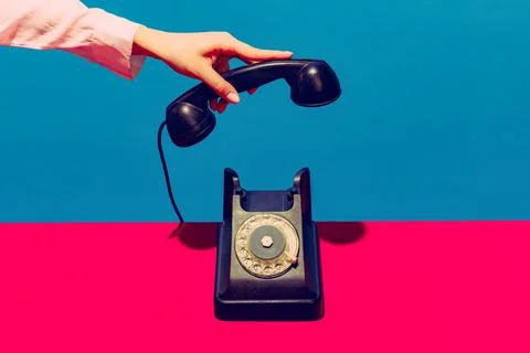 Retro objects, gadgets. Female hand holding handset of vintage phone isolated on Stock Photos