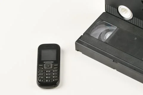 Retro objects on a white background. push-button telephone and video cassette Stock Photos