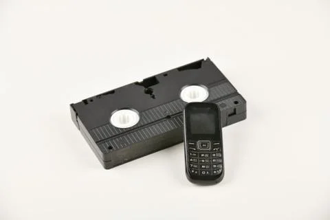 Retro objects on a white background. push-button telephone and video cassette Stock Photos