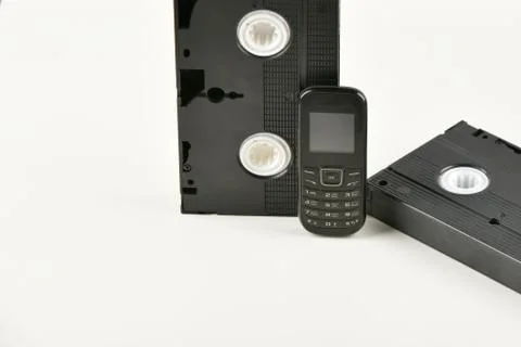 Retro objects on a white background. push-button telephone and video cassette Foto stock