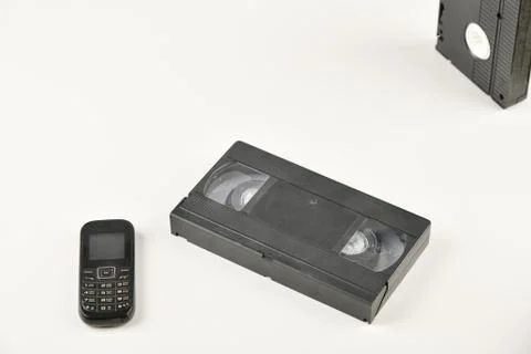 Retro objects on a white background. push-button telephone and video cassette Stock Photos