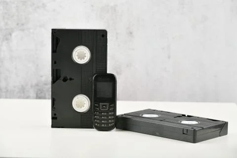 Retro objects on a white background. push-button telephone and video cassette Stock Photos