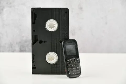 Retro objects on a white background. push-button telephone and video cassette Stock Photos
