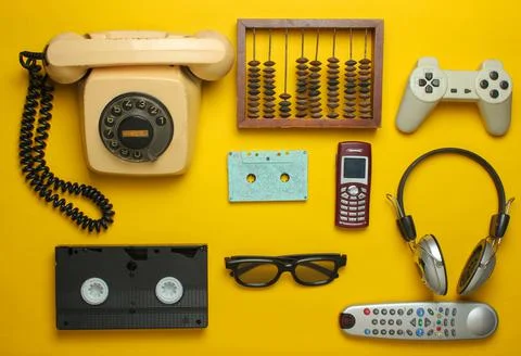 Retro objects on a yellow background. Rotary telephone, audio cassette, video Stock Photos