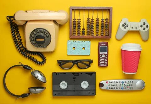 Retro objects on a yellow background. Rotary telephone, audio cassette, video Stock Photos