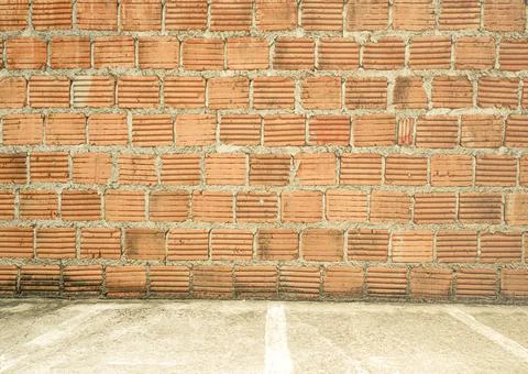 Retro old brown bricks background set up beside concrete road. Stock Photos