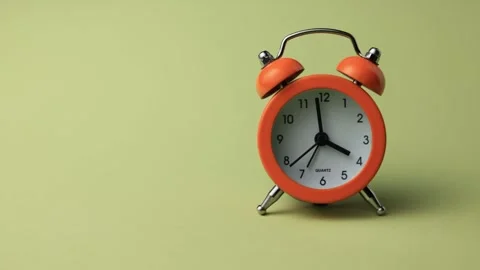 Retro orange alarm clock on a light green background, minimalist composition Stock Footage 338995980