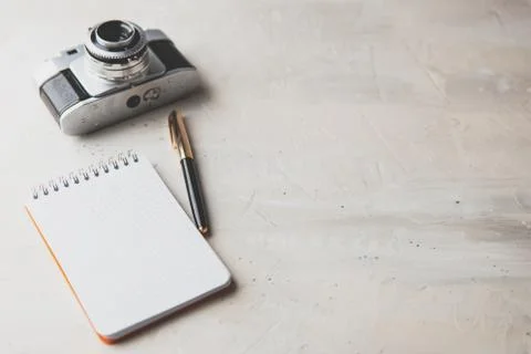 Retro photo camera with white note book on a stylish wooden background Stock Photos