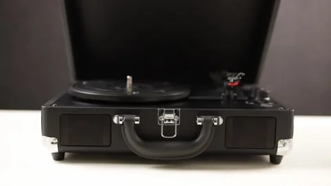 Retro portable record player with a hand opening the lid and playing music Stock Footage 339003769