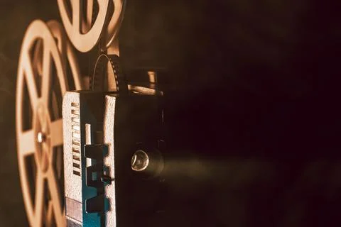 Retro projector playing motion picture. dark room. Timeless flicker of old .. Stock Photos