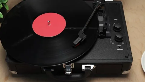 Retro record player with black vinyl spinning on a wooden table Vidéo 340844752