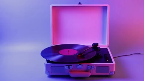 Retro record player with vinyl spinning under colorful neon lights Stockbeeldmateriaal 339275806