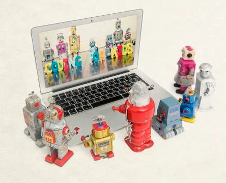 Retro robots learn coding  from a laptop Foto stock