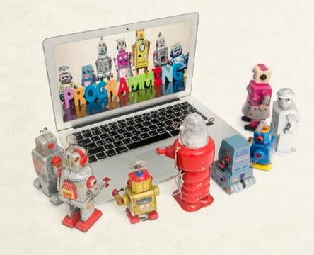 Retro robots learn programming from a laptop Stock Photos