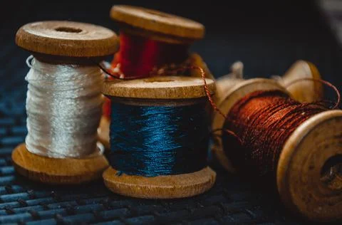 Retro sewing items: tailoring scissors, cutting knife, thimble, wooden thread Stock Photos