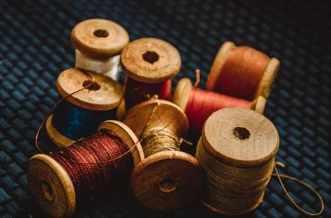 Retro sewing items: tailoring scissors, cutting knife, thimble, wooden thread Stock Photos