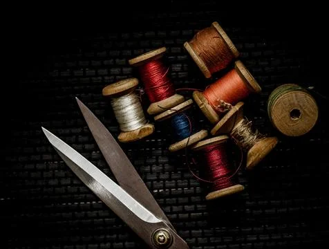 Retro sewing items: tailoring scissors, cutting knife, thimble, wooden thread Stock Photos