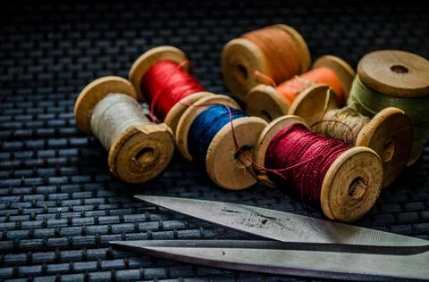 Retro sewing items: tailoring scissors, cutting knife, thimble, wooden thread Stock Photos