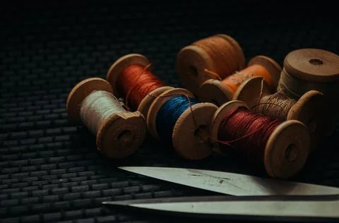 Retro sewing items: tailoring scissors, cutting knife, thimble, wooden thread Stock Photos