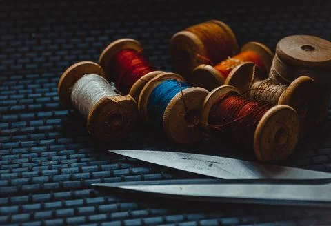 Retro sewing items: tailoring scissors, cutting knife, thimble, wooden thread Stock Photos