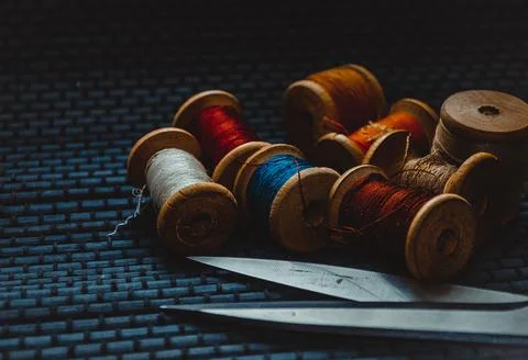 Retro sewing items: tailoring scissors, cutting knife, thimble, wooden thread Stock Photos