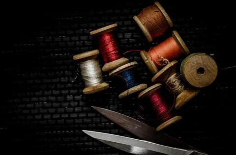 Retro sewing items: tailoring scissors, cutting knife, thimble, wooden thread Stock Photos