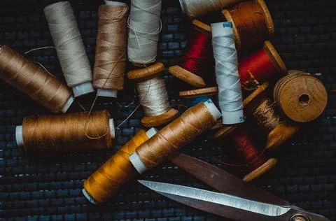 Retro sewing items: tailoring scissors, cutting knife, thimble, wooden thread Stock Photos