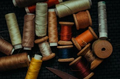 Retro sewing items: tailoring scissors, cutting knife, thimble, wooden thread Stock Photos