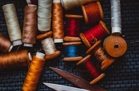 Retro sewing items: tailoring scissors, cutting knife, thimble, wooden thread Stock Photos