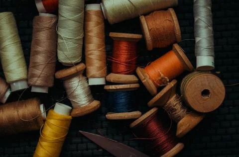 Retro sewing items: tailoring scissors, cutting knife, thimble, wooden thread Stock Photos