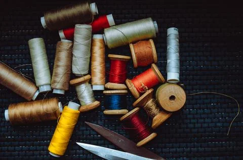 Retro sewing items: tailoring scissors, cutting knife, thimble, wooden thread Stock Photos
