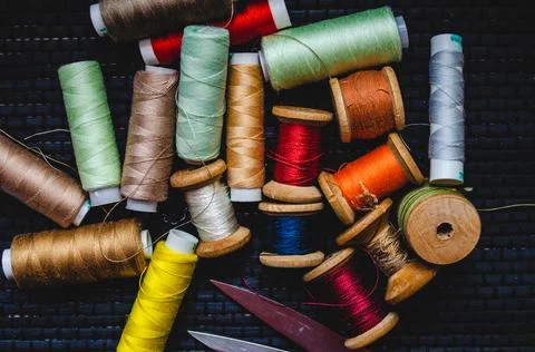 Retro sewing items: tailoring scissors, cutting knife, thimble, wooden thread Stock Photos
