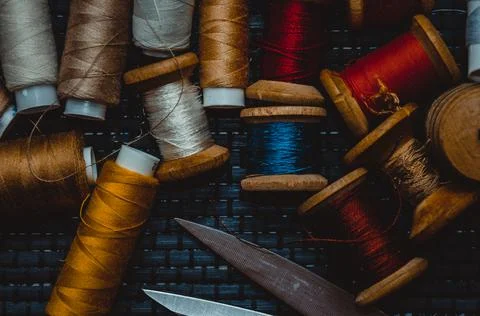 Retro sewing items: tailoring scissors, cutting knife, thimble, wooden thread Stock Photos