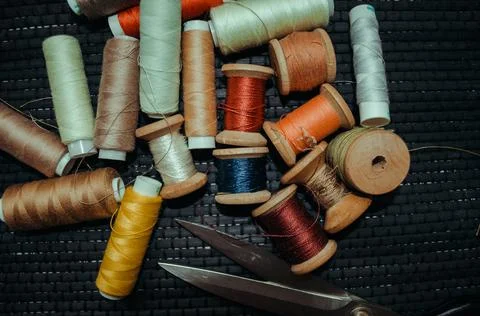 Retro sewing items: tailoring scissors, cutting knife, thimble, wooden thread Stock Photos