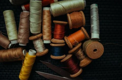 Retro sewing items: tailoring scissors, cutting knife, thimble, wooden thread Stock Photos