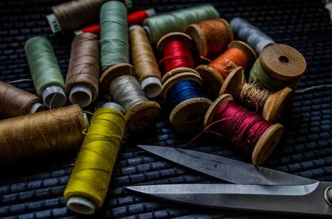 Retro sewing items: tailoring scissors, cutting knife, thimble, wooden thread Stock Photos