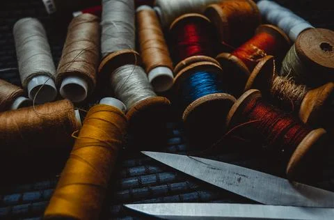 Retro sewing items: tailoring scissors, cutting knife, thimble, wooden thread Stock Photos