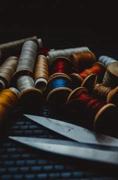 Retro sewing items: tailoring scissors, cutting knife, thimble, wooden thread Stock Photos